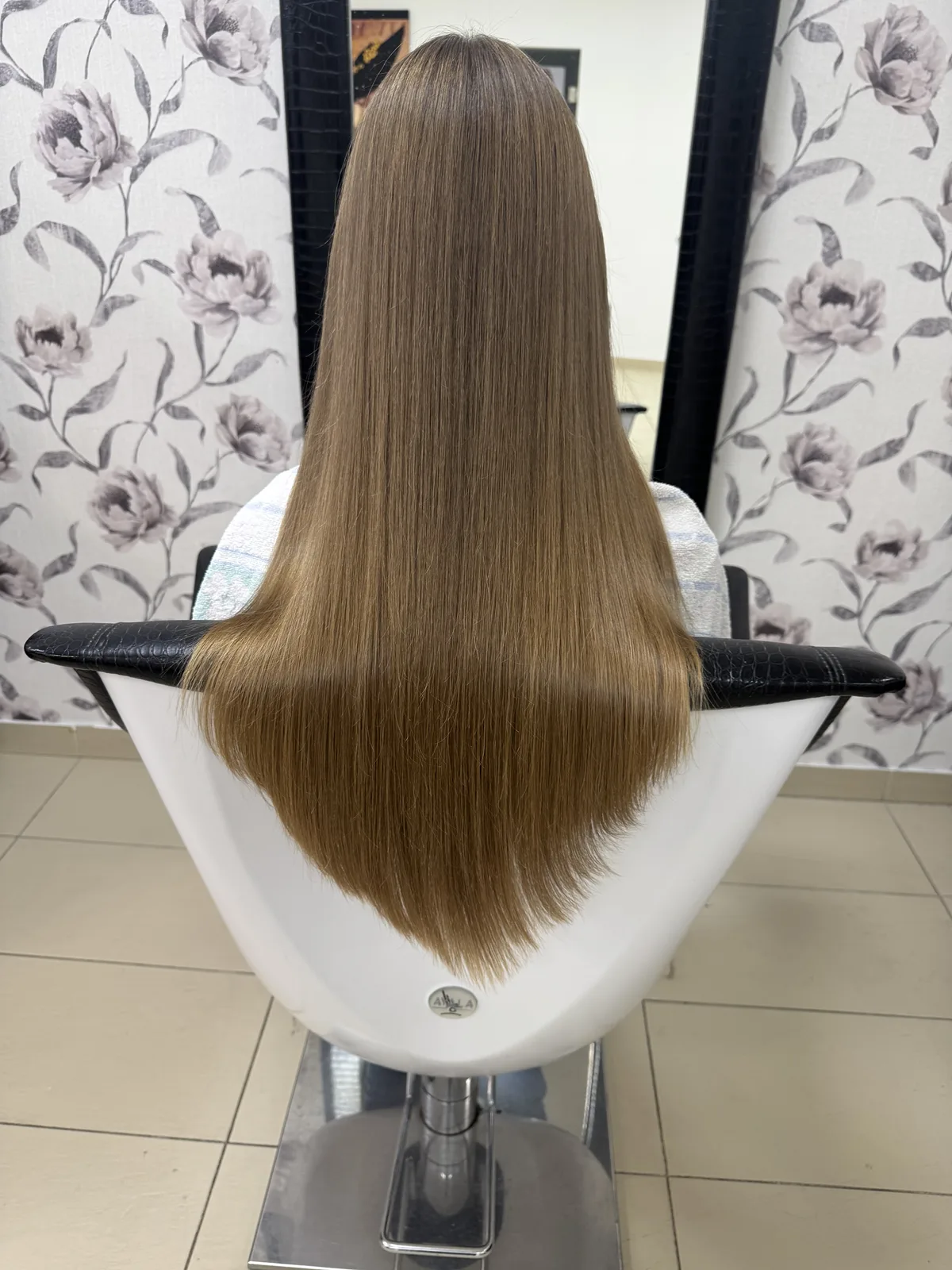 Dlhé medovo-blond vlasy v kaderníckom kresle